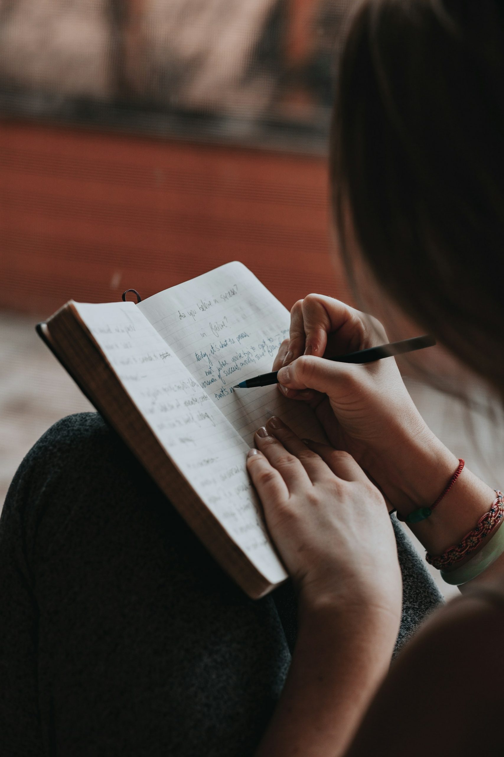 Handwriting an essay draft in a notebook