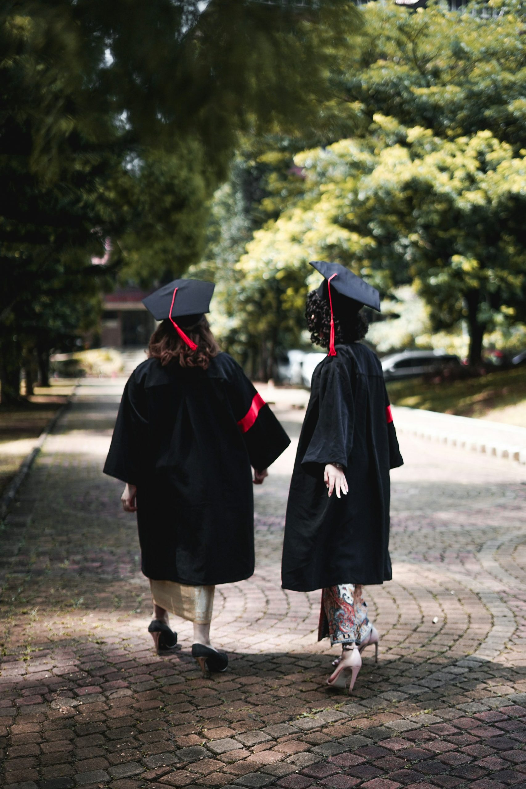 Two graduates walking together in cap and gown